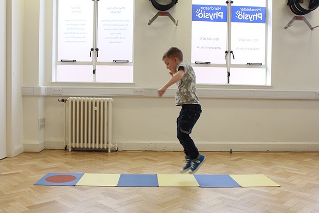 Child jumping between mats during an assessment
