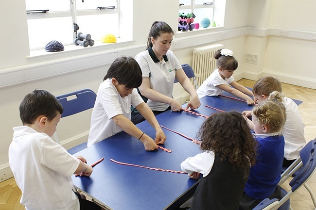 Children in group, playing with theraputty, therapist leading 