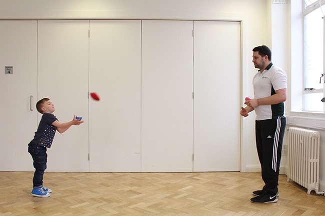 Child catching beanbags thrown by therapist