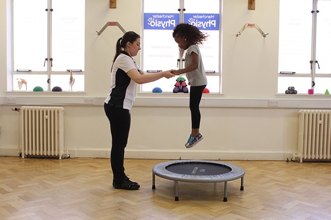 Therapist supporting child balancing on all fours