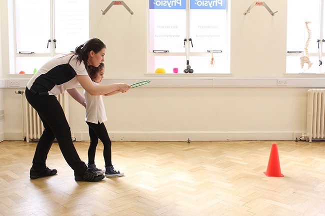 Child and Therapist throwing at a target